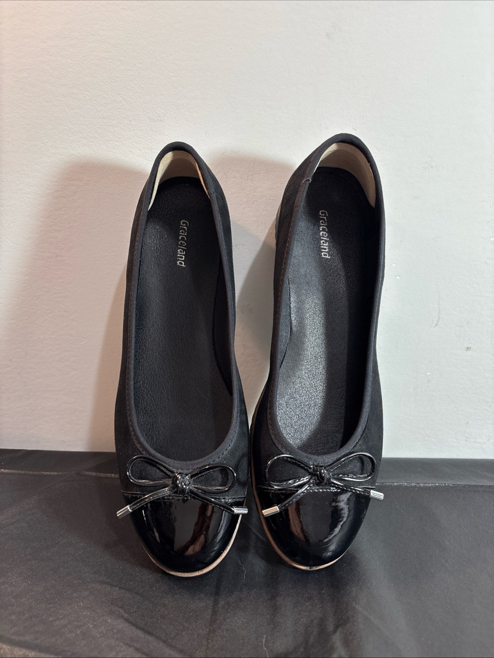 Graceland Black Ballet Flats with Patent Cap Toe and Bow. 9/13